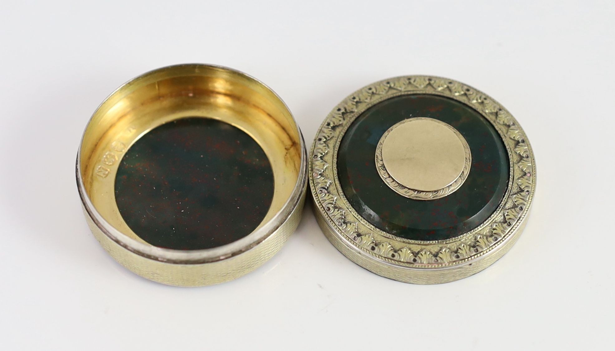 A George III engine turned silver gilt and inset bloodstone circular snuff box and cover, maker's mark rubbed